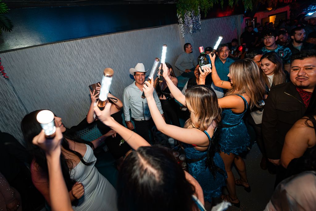 Guests dancing with LED light sticks and a bottle raised at Zuna Nightclub in Las Vegas